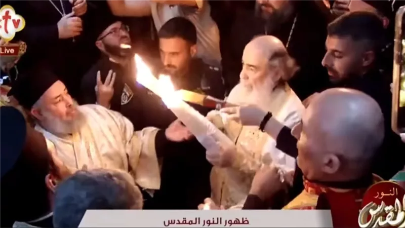 ظهور النور المقدس الآن من قبر المسيح وبطريرك القدس يخرج بالشعلة المضيئة من كنيسة القيامة 
